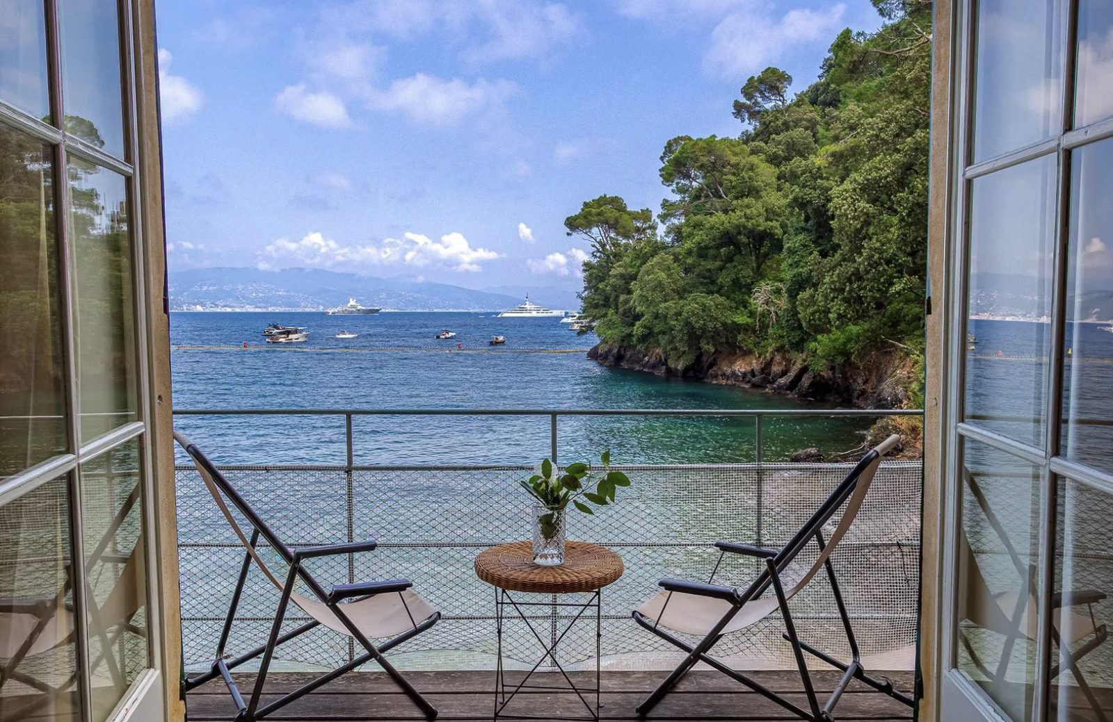 Balcony with two chairs overlooking the harbor and coastline of Portofino, Italy