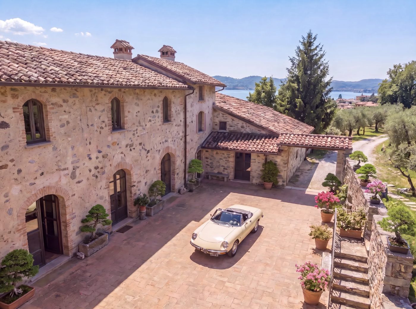 Restored stone farmhouse with lake and hills in the background, northern Italy